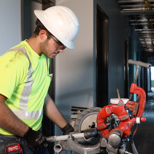 Fire sprinkler fitter cutting pipe